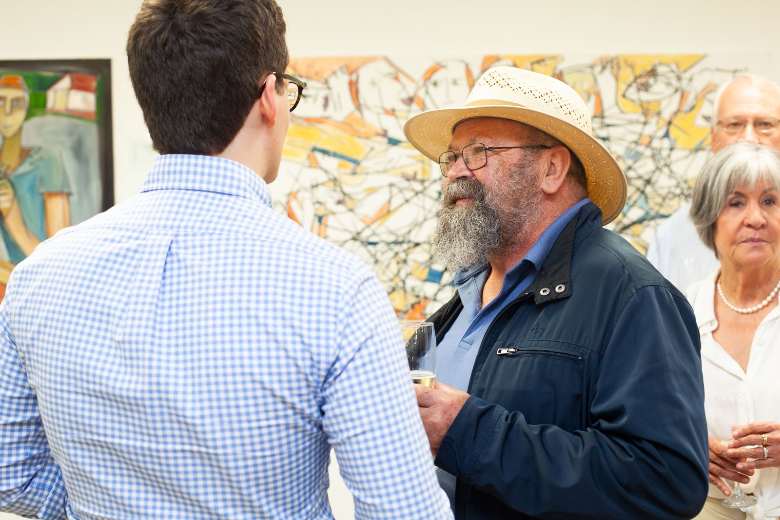 Flávio Scholles conversando com convidado durante a abertura da galeria
